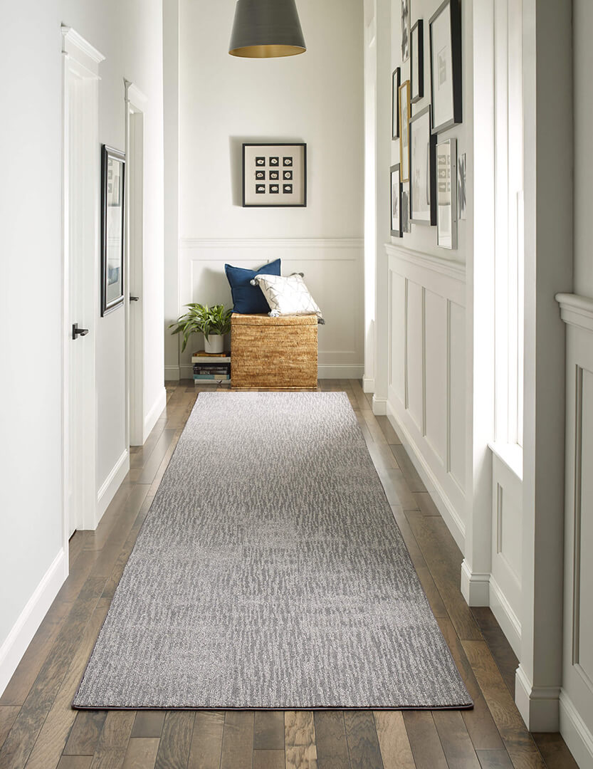 neutral colored area rug in a hallway 